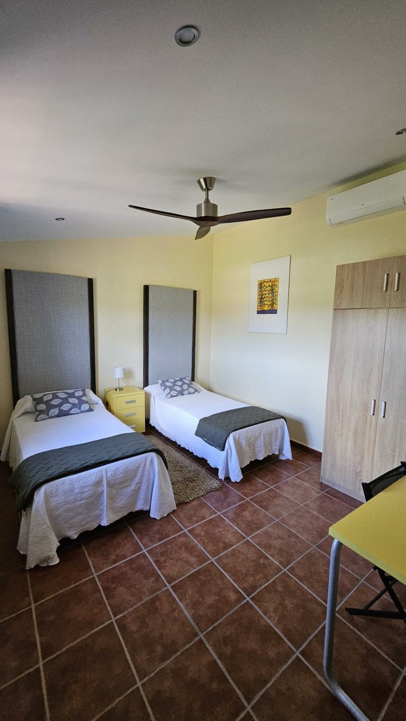 Habitación doble con dos camas individuales, armario, ventilador de techo y aire acondicionado